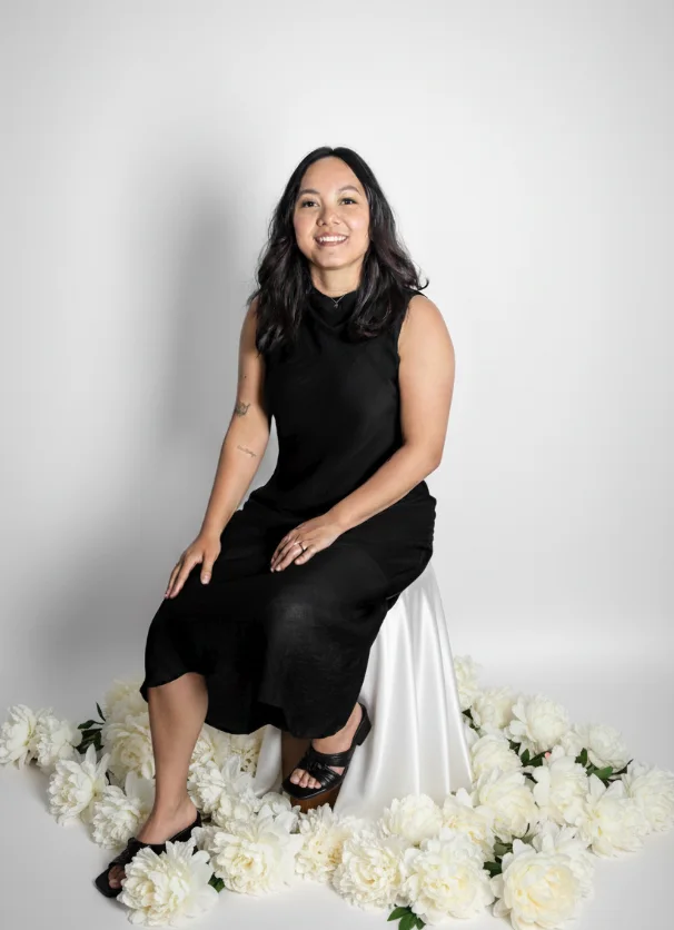 Isabela Moreira, founder of Alicante Wedding Planner, seated among white flowers